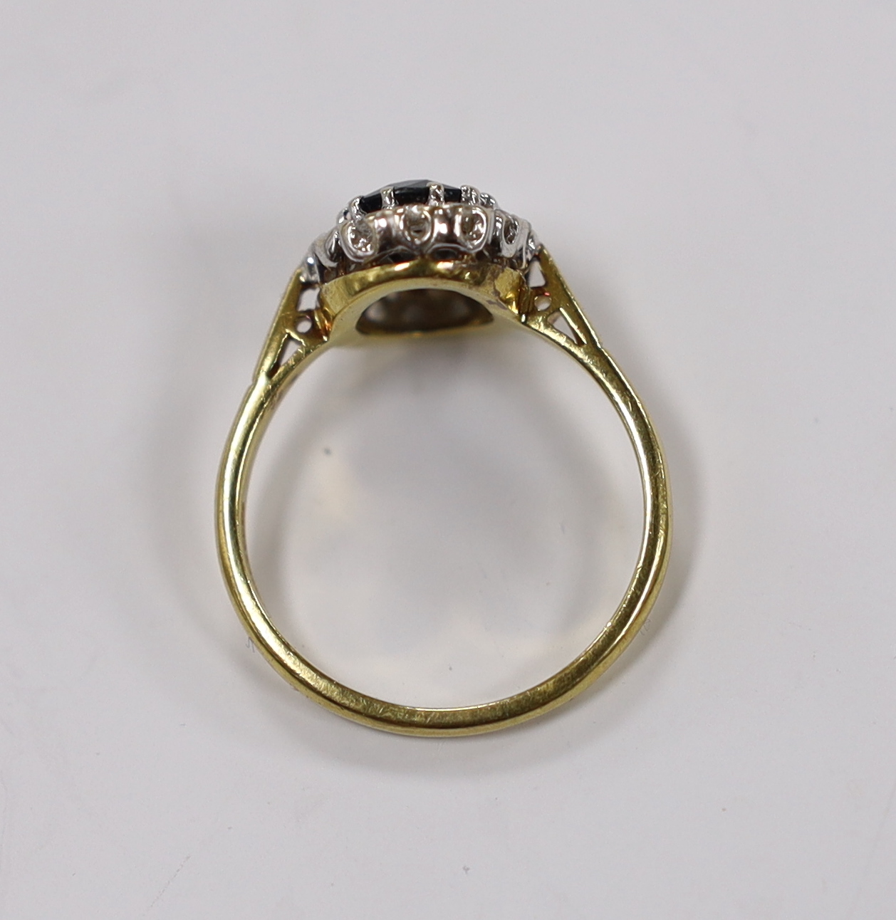 A modern 18ct gold, sapphire and diamond set oval cluster ring, size Q, gross weight 4.9 grams.